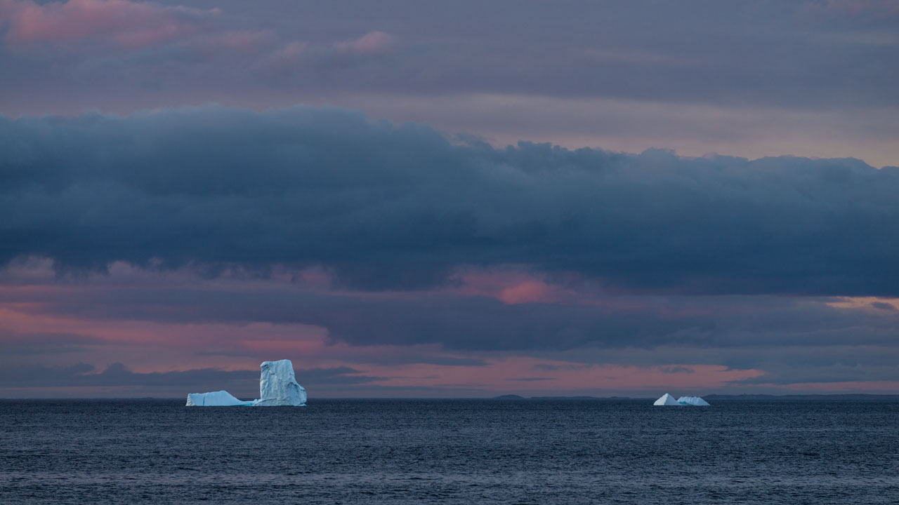 Unsere ersten Eisberge aus der Ferne bei Abendrot. Neufundland, Kanada